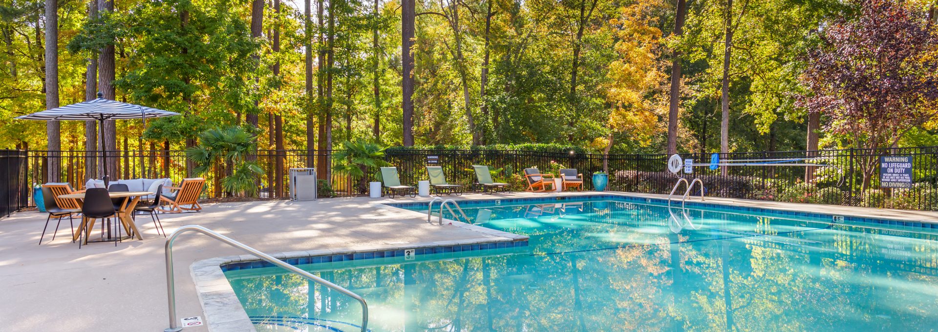 a pool surrounded by trees and a patio at The  Sawyer